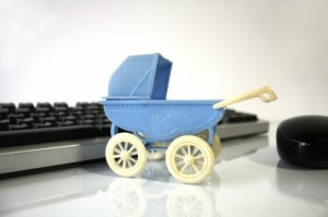 Kinderwagen vor Computertastatur