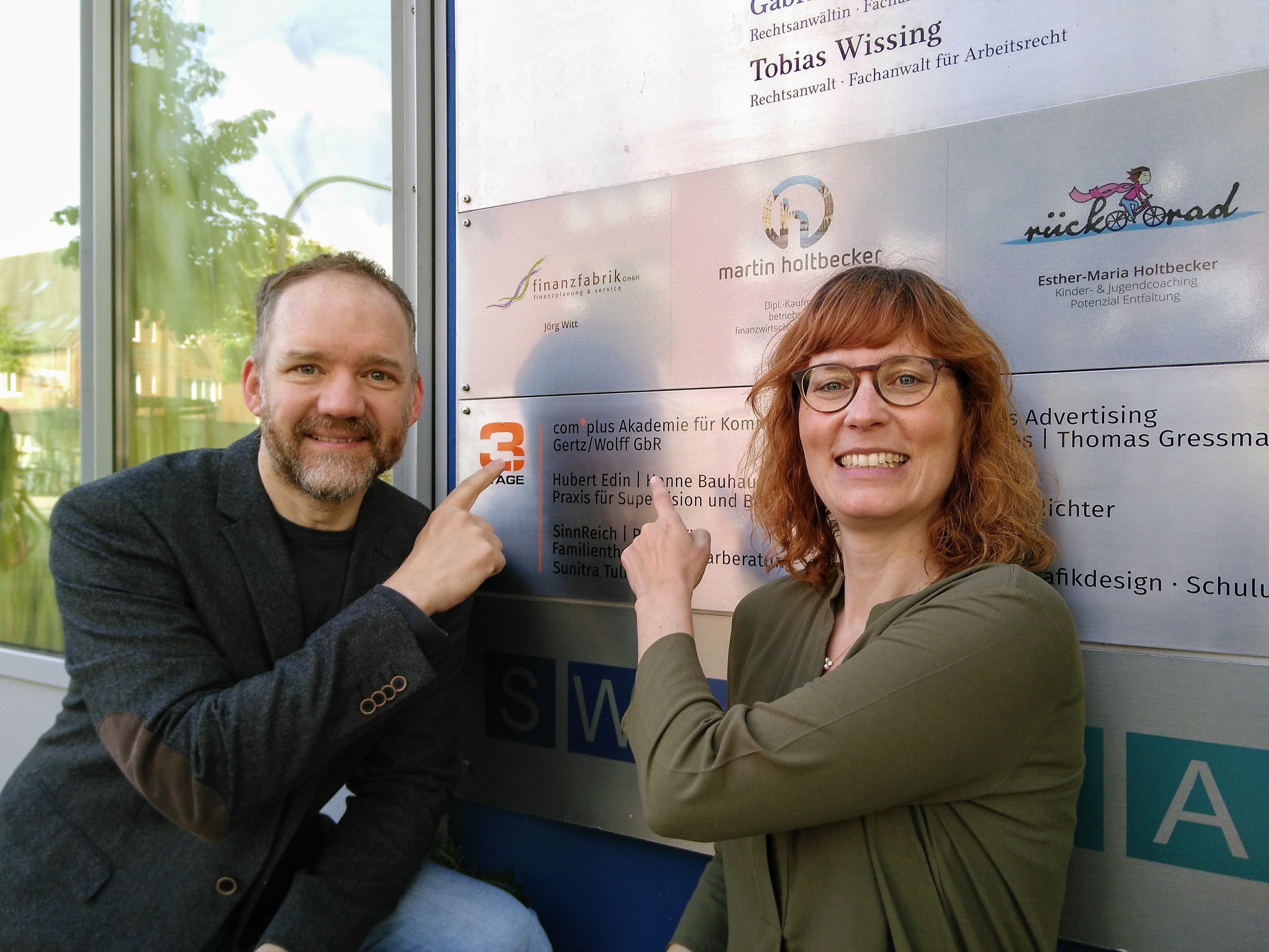 Christian Gertz und Constanze Wolff vor ihrem neuen Schild der complus Akademie für Kommunikation.