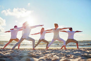 Eine yogapraktizierende Gruppe Menschen an der Nordsee